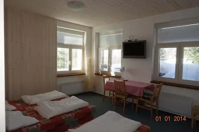 a room with two beds and a table and a television at loft panorama Tre cime Dobbiaco Cortina in Dobbiaco