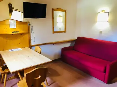 a living room with a red couch and a table at loft panorama Tre cime Dobbiaco Cortina in Dobbiaco