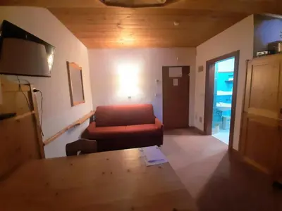 a living room with a red couch and a table at loft panorama Tre cime Dobbiaco Cortina in Dobbiaco