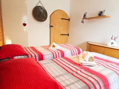 two beds in a room with red and white blankets at Tina's House - Alpine Stay Apartments in Cavalese