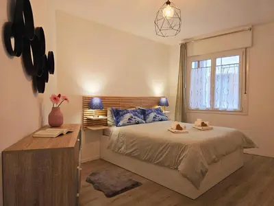 a bedroom with a bed with a desk and a window at Tina's House - Alpine Stay Apartments in Cavalese