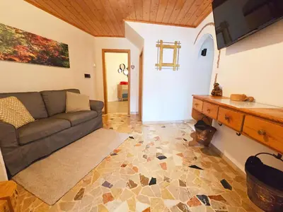 a living room with a couch and a table at Tina's House - Alpine Stay Apartments in Cavalese