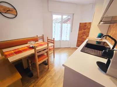 a kitchen with a table and a table and a stove at Tina's House - Alpine Stay Apartments in Cavalese