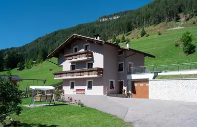 a white house with a hill in the background at Appartamento Brunel in Pera
