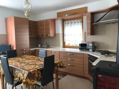 a kitchen with a table with chairs and a dining room at Appartamento Elisa in Taibon