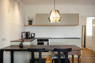 a kitchen with a wooden table and chairs at Karcher-Hof Terlan in Terlano
