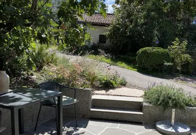 a patio with a table and chairs and a garden at Karcher-Hof Terlan in Terlano