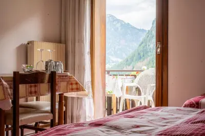 a bedroom with two beds and a window at Cèsa Cherpei - Dog Friendly in Campitello di Fassa