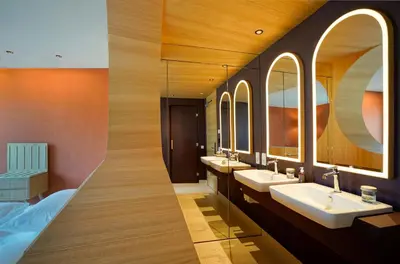 a bathroom with three sinks and two mirrors at Hotel La Briosa in Bolzano