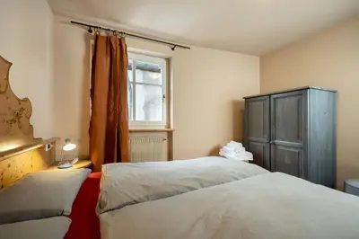 a bedroom with two beds and a window at Ciasa Buro - Coba in Moena