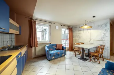 a kitchen and dining room with a table and chairs at Ciasa Buro - Coba in Moena