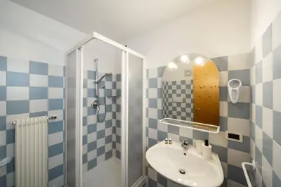 a bathroom with a sink and a shower with a mirror at Ciasa Buro - Coba in Moena