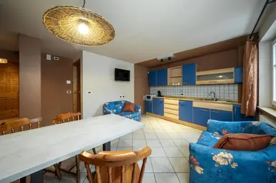 a kitchen with blue cabinets and a table and chairs at Ciasa Buro - Coba in Moena