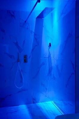 a bathroom with a shower with blue lighting at Your Stay in Bolzano in Bolzano