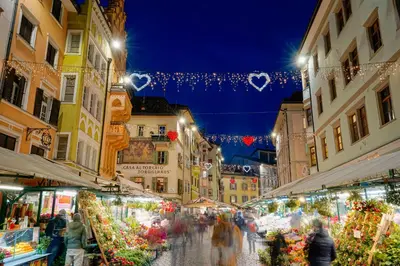 a group of people walking through a market at night at Your Stay in Bolzano in Bolzano