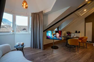 a living room with a couch and a tv and a table at Your Stay in Bolzano in Bolzano