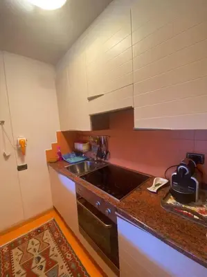 a kitchen with a sink and a counter top at Encia's Home Dolomiti in Castello di Fiemme