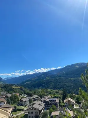 a view of a city with mountains in the background at Encia's Home Dolomiti in Castello di Fiemme
