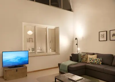 a living room with a couch and a flat screen tv at Argentieri City Loft in Bolzano