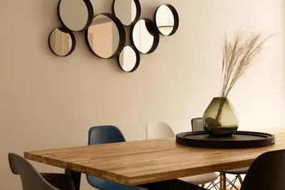 a dining room with a wooden table and mirrors on the wall at Argentieri City Loft in Bolzano