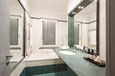 a bathroom with a white tub and a sink at Argentieri City Loft in Bolzano