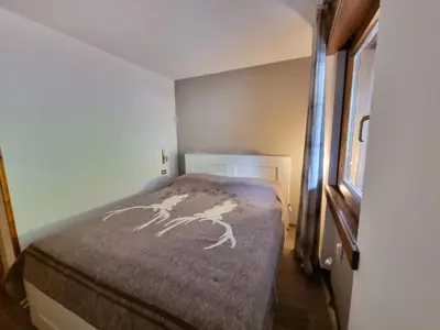 a small bedroom with a bed in a room at Contrin in Canazei