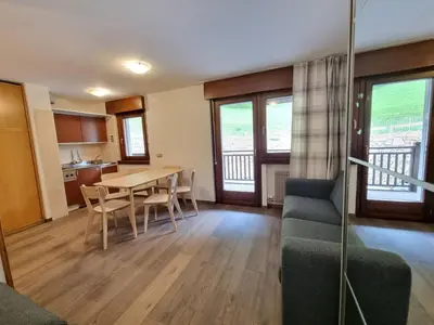a living room with a table and chairs at Contrin in Canazei