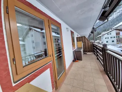 a balcony with a large glass door on a building at Contrin in Canazei