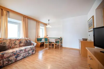 a living room with a couch and a table at Central Apartments Cristlpek in Ortisei