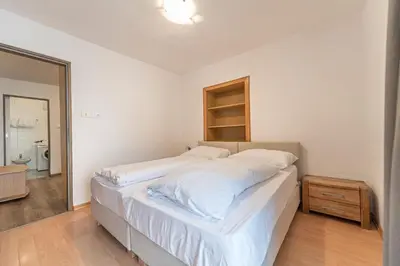 a bedroom with a large bed and a mirror at Central Apartments Cristlpek in Ortisei