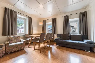 a living room with a couch and a table and chairs at Central Apartments Cristlpek in Ortisei