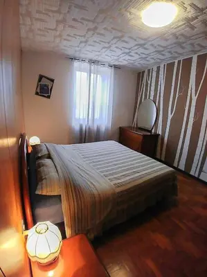 a bedroom with a bed and a table and a window at da Stoimenov in Fondo