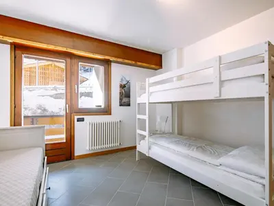 a bedroom with two bunk beds and a window at Apartment Appartamento 29 by Interhome in Alba di Canazei