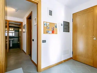 a hallway with a wooden door and a tile floor at Apartment Appartamento 29 by Interhome in Alba di Canazei