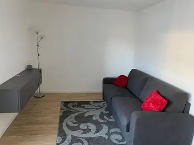 a living room with a blue couch and red pillows at Via hofer in Brunico