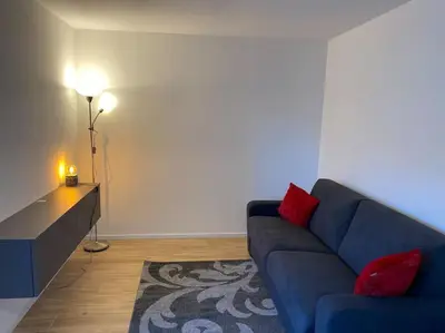a living room with a blue couch and a lamp at Via hofer in Brunico