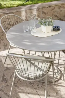 a white table and chair with a plate and glasses at Villa Stubai Garden Suite in Merano