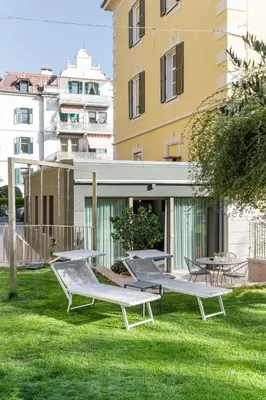 a group of benches in the grass in front of a building at Villa Stubai Garden Suite in Merano