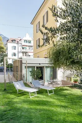 a yard with two benches and a building at Villa Stubai Garden Suite in Merano