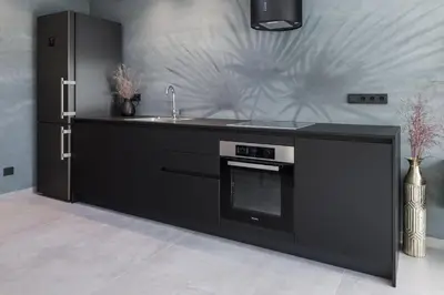 a black kitchen with a sink and a stove at Villa Stubai Garden Suite in Merano