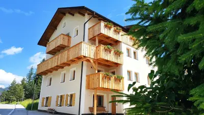 a building with wooden balconies on the side of it at Villa Erica in Badia