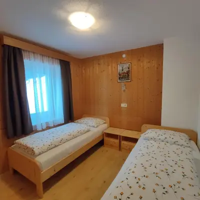a bedroom with two beds and a window at Villa Erica in Badia