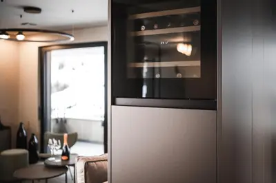 a kitchen with a microwave and a table with a dining room at Avita Loft by Avita suites to relax in Santa Cristina in Val Gardena