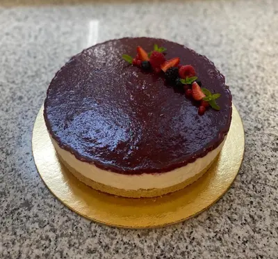 a chocolate cake with strawberries on top on a plate at Garní Ladinia in Pescul