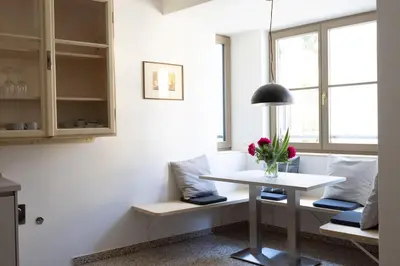 a living room with a white table and a vase of flowers at DOMUS FABER in Merano