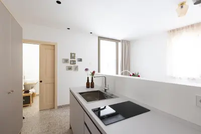 a white kitchen with a sink and a window at DOMUS FABER in Merano