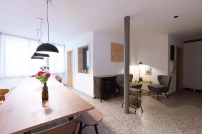 a living room with a table with a vase of flowers on it at DOMUS FABER in Merano