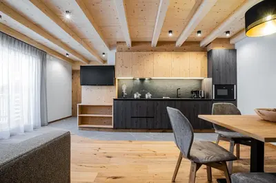 a bedroom with a large bed with a wooden wall at Bio Lüch Ruances in San Cassiano