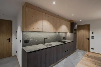 a kitchen with a sink and wooden cabinets at Bio Lüch Ruances in San Cassiano