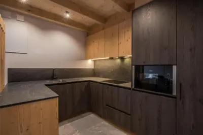 a kitchen with wooden cabinets and a microwave at Bio Lüch Ruances in San Cassiano